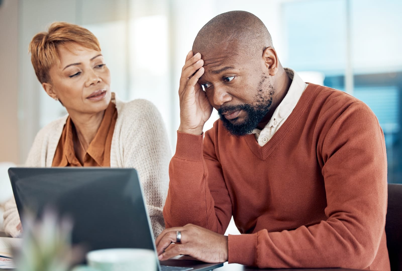 stress-finance-and-laptop-by-senior-couple-checking-budget-savings-and-expenses-while-paying-bills-in-kitchen-anxiety-family-and-debt-by-black-woman-disappointed-annoyed-and-frustrated-with-man